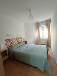Un dormitorio con una cama verde y una ventana en Apartamento La Planchada en El Astillero