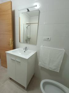 biała łazienka z umywalką i toaletą w obiekcie Apartamento La Planchada w mieście El Astillero