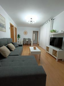 sala de estar con sofá y TV en Apartamento La Planchada en El Astillero