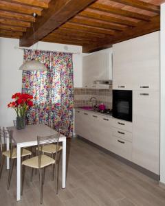 a kitchen with white cabinets and a table and chairs at Tana Dell'Orso in Ponsacco