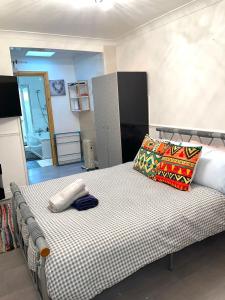ein Schlafzimmer mit einem großen Bett mit einer schwarzen und weißen Decke in der Unterkunft Impeccable Spacious 6-Bed House in Romford in Romford