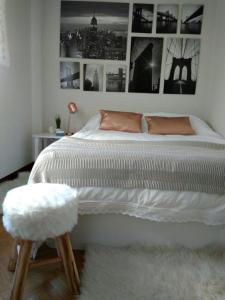 a bedroom with a large white bed with a stool at VUT Casa Miranda 51 in Salamanca