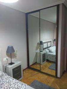 a mirror in a bedroom with a bed and a lamp at VUT Casa Miranda 51 in Salamanca