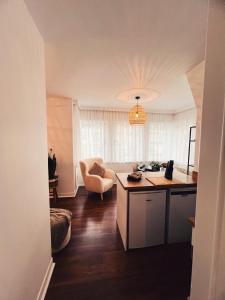 a kitchen and living room with a table and a chair at Studio Bella in De Panne