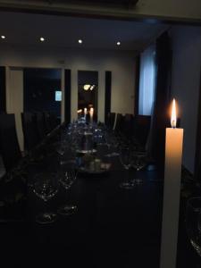 una mesa larga con copas de vino y una vela en Safaritalo Cottages, en Kalajoki