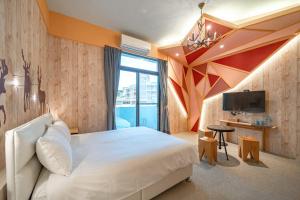 a bedroom with a large white bed and a tv at 精彩奇寓站前電梯主題民宿走路到車站好停車 in Hualien City