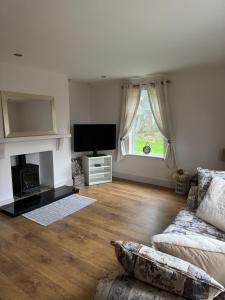 un soggiorno con divano e TV di Riverview Cottage a Gortnessy Upper