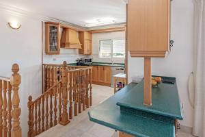 a kitchen with wooden cabinets and a green counter top at Villa Dos Perlas in Alicante