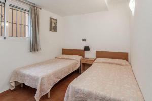 two beds in a room with a desk and a window at Villa Dos Perlas in Alicante +37 photos