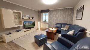 uma sala de estar com um sofá azul e uma televisão em Dünenpark Binz by Rujana em Binz