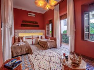 um quarto com 2 camas num quarto com paredes vermelhas em Riad Maialou & SPA em Marrakech
