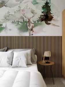ein Schlafzimmer mit einem Bett mit einem Hirschgemälde in der Unterkunft Hotel Etropol, Center Etropole in Etropole