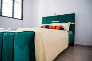 a bedroom with a large bed with a green headboard at Stunning 4-Bed Villa in cocody engre Abidjan in Cocody