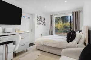 a white bedroom with a bed and a window at Little Laxford in Fazeley