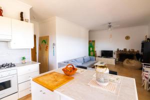 una cocina con armarios blancos y una mesa en una habitación en Captivating 2-Bed House, en Alaminos
