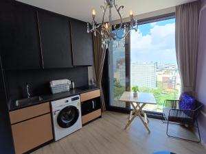 a kitchen with a washing machine and a table and a window at Downtown Chic Condo High Floor #E59 in Pattaya Central