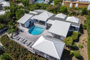Magnifique villa rénovée neuve à Orient Bay في سانت مارتن: اطلالة جوية على منزل مع مسبح