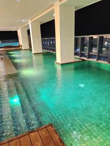 an indoor swimming pool with green water in a building at The City Escape in Cebu City