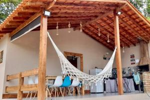 una hamaca colgando del toldo de una casa en Chácara prox Rota do Vinho com piscina, churrasqueira, área verde, animaizinhos e muito sossego, en São Roque