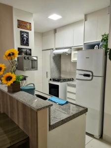 a kitchen with white cabinets and a white refrigerator at Vg Sun Cumbuco C1407 Studium in Cumbuco +32 photos