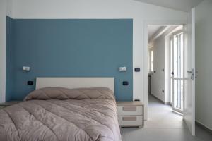 ein Schlafzimmer mit einem Bett und einer blauen Wand in der Unterkunft Strategic Apartment with Terrace - Nola in Nola