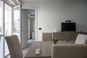 ein Esszimmer mit einem Tisch und einem TV in der Unterkunft Strategic Apartment with Terrace - Nola in Nola