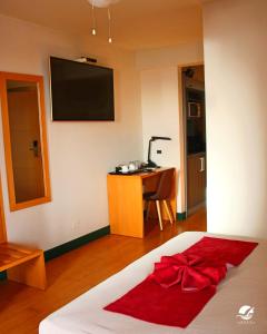 a bedroom with a bed with a red bow on it at Pombas Brancas Hotel in Mindelo