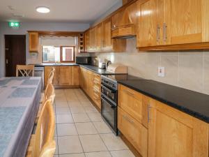 a kitchen with wooden cabinets and a black counter top at The Garden Cottage in Crossmaglen