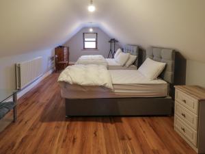 a bedroom with a large bed in a attic at The Garden Cottage in Crossmaglen
