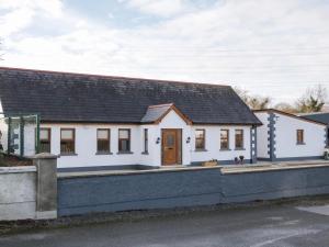 a white house with a black roof at The Garden Cottage in Crossmaglen