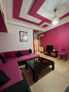 uma sala de estar com um sofá roxo e uma mesa em Holidays HOUSE em La Marsa