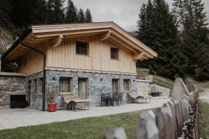 a house with a wooden roof and a patio at Bergler Hoamat - Mountain Hideaway in Navis