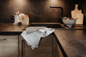um balcão de cozinha com um lavatório e uma toalha em Bergler Hoamat - Mountain Hideaway em Navis