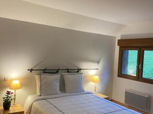 茹普特河畔巴斯特爾的住宿－Guestroom Basse-sur-le-Rupt, 1 pièce, 2 personnes - FR-1-589-626，一间卧室配有一张带两盏灯的床和一扇窗户。