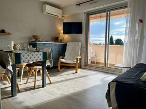 Habitación con mesa de comedor y cocina con balcón. en Appartement Cavalaire-sur-Mer, 2 pièces, 4 personnes - FR-1-226B-178, en Cavalaire-sur-Mer