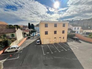 un estacionamiento con un edificio y un coche aparcado en Appartement Cavalaire-sur-Mer, 2 pièces, 4 personnes - FR-1-226B-178, en Cavalaire-sur-Mer