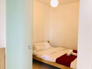 um quarto com uma cama com lençóis brancos e almofadas em Joy City Stay Vivalia V4-5 em Timisoara