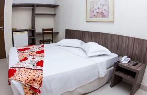um quarto com uma cama e uma mesa com um telefone em Ara Mar Praia Hotel em Fortaleza