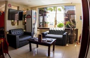 a living room with two chairs and a coffee table at Ara Mar Praia Hotel in Fortaleza