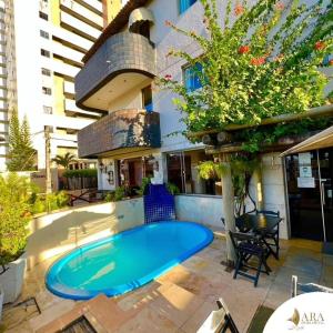 a swimming pool in front of a building at Ara Mar Praia Hotel in Fortaleza