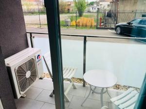 uma varanda com um aquecedor, uma mesa e um carro em Joy City Stay Vivalia V4-5 em Timisoara