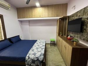 a bedroom with a bed and a flat screen tv at Amazing AC Studio in E City 3F 302 in Bangalore