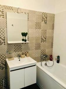 uma casa de banho com um lavatório, um espelho e uma banheira em Joy City Stay Vivalia V4-5 em Timisoara