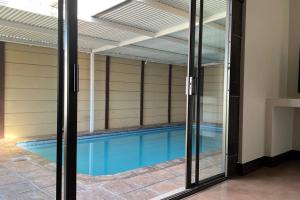 a swimming pool seen through a glass door at Bosch Villa in Cape Town