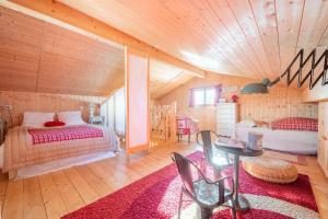 a bedroom with two beds and a table in a room at Chalet L’Embellie - Chalet avec piscine partagée in Saint-Laurent-en-Grandvaux +19 photos