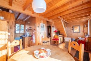 een eetkamer met een tafel in een blokhut bij Chalet L’Embellie - Chalet avec piscine partagée in Saint-Laurent-en-Grandvaux