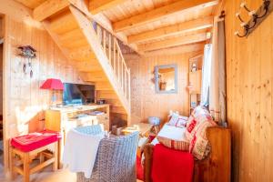 una sala de estar con una escalera en una cabaña de madera en Chalet L’Embellie - Chalet avec piscine partagée, en Saint-Laurent-en-Grandvaux