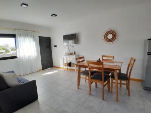 sala de estar con mesa de madera y sillas en Confort urbano - Departamento en Venado Tuerto