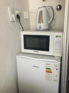 un forno a microonde seduto sopra un frigorifero di Studio en Chihuahua a Punta del Este