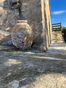 a large brick vase sitting next to a building at Nigos in Okhiá